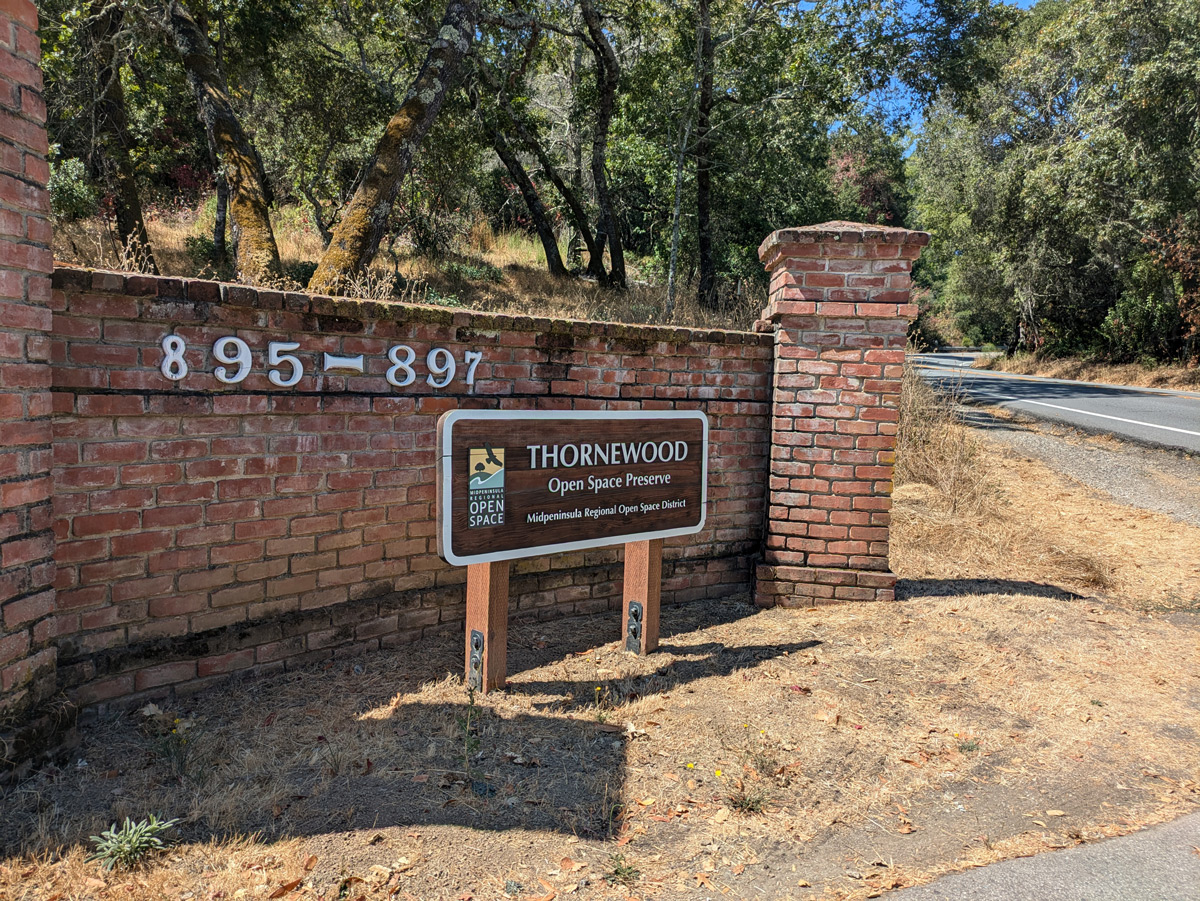 A brick entrance with a sign for an open space preserve.